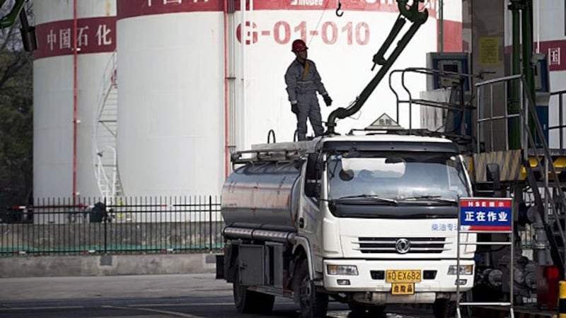 A worker fills an oil truck at a China Petroleum & Chemical Corp. filling station in Shanghai, China, March 22, 2018.