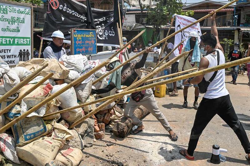 Protesters reinforce their barricade with wooden stakes to fend off security forces during a crackdown in Yangon this week. (AFP)