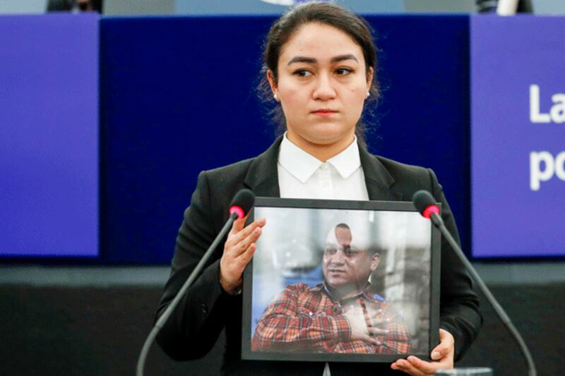 Jewher Ilham, daughter of Ilham Tohti, holds a photo of her father during the Sakharov Prize ceremony at the European Parliament in Strasbourg, France, Dec. 18, 2019. (Jean-Francois Badias/AP)