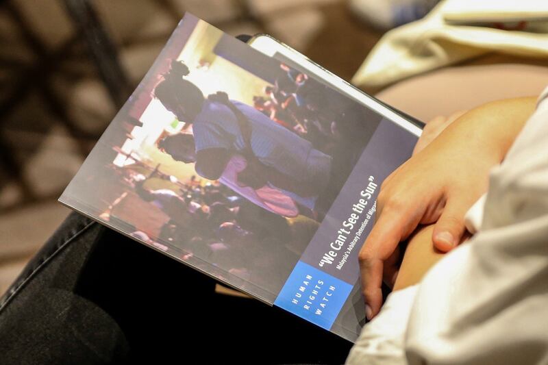 A woman holds a copy of the Human Rights Watch report “‘We Can’t See the Sun’: Malaysia – Arbitrary Detention of Migrants and Refugees” during its release in Petaling Jaya, March 6, 2024. (S. Mahfuz/BenarNews)