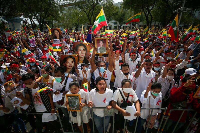 Myanmar nationals display pictures of deposed Myanmar leader Aung San Suu Kyi during a protest against the military coup in front of the United Nations building in Bangkok, Thailand, March 2021. Credit: Nava Sangthong/AP