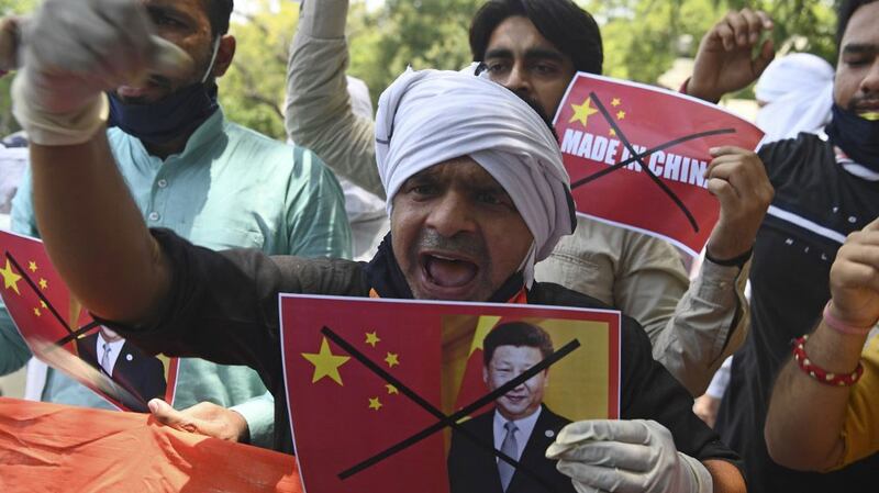 A demonstrator shouts slogans while holding a poster of Chinese President Xi Jinping during an anti-China protest near Chinese embassy in New Delhi, June 17, 2020. 