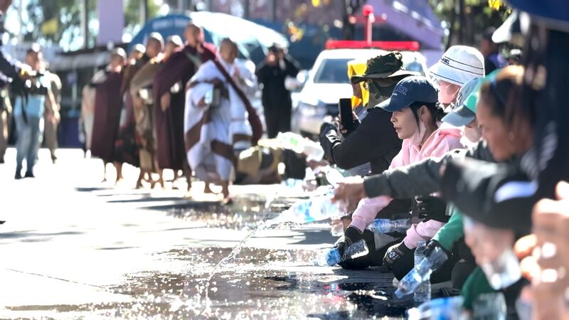 Thai well-wishers sprinkle water as Vietnamese monk Thich Minh Tue walks through Chong Mek, Ubon Ratchathani Province, Thailand, on his way to India., Dec. 31, 2024.