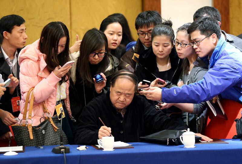 Chinese novelist Mo Yan (given name Guan Moye), 2012 Nobel Prize Laureate for Literature, who is also a delegate of Chinese People's Political Consultative Conference (CPPCC), is seen surrounded by journalists after a group discussion of CPPCC in Beijing, March 4, 2014.