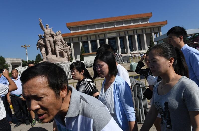 Visitors leave after viewing the preserved body of late communist leader Mao Zedong in his mausoleum [at rear] in Beijing's Tiananmen Square, Sept. 8, 2016. (Greg Baker/AFP)