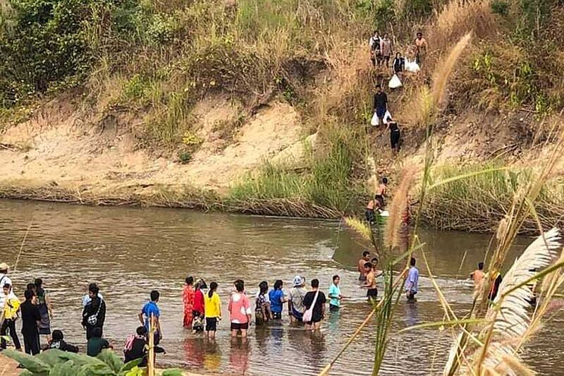 Residents cross a river in Kayah State along the Thai-Myanmar border as they flee fighting between the Myanmar junta and the Karen National Union (KNU) on Dec. 25, 2021. (AFP)