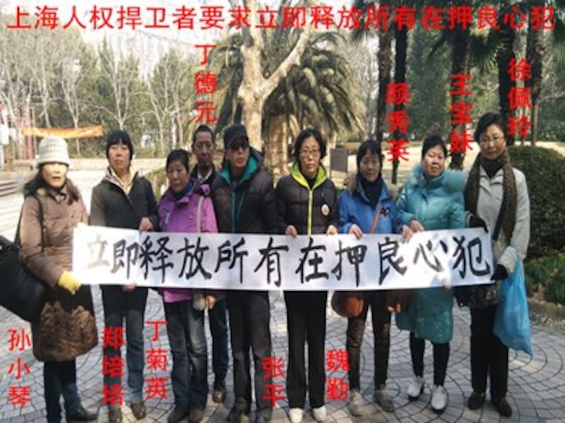 Shanghai activists hold up a banner in the city's People's Park, calling for the immediate release of all political prisoners, Feb. 9, 2016.