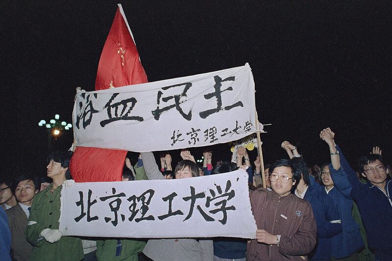 1989年4月22日早晨，北京工业大学学生手持横幅“浴血民主”，游行进入天安门广场。（美联社）