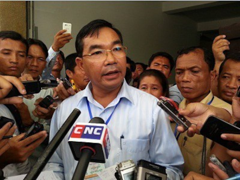 Senior SNRP member Kuy Bunroeun speaks to reporters after Siem Reap security packages are opened at the NEC headquarters in Phnom Penh, Aug. 30, 2013. Photo credit: RFA. 