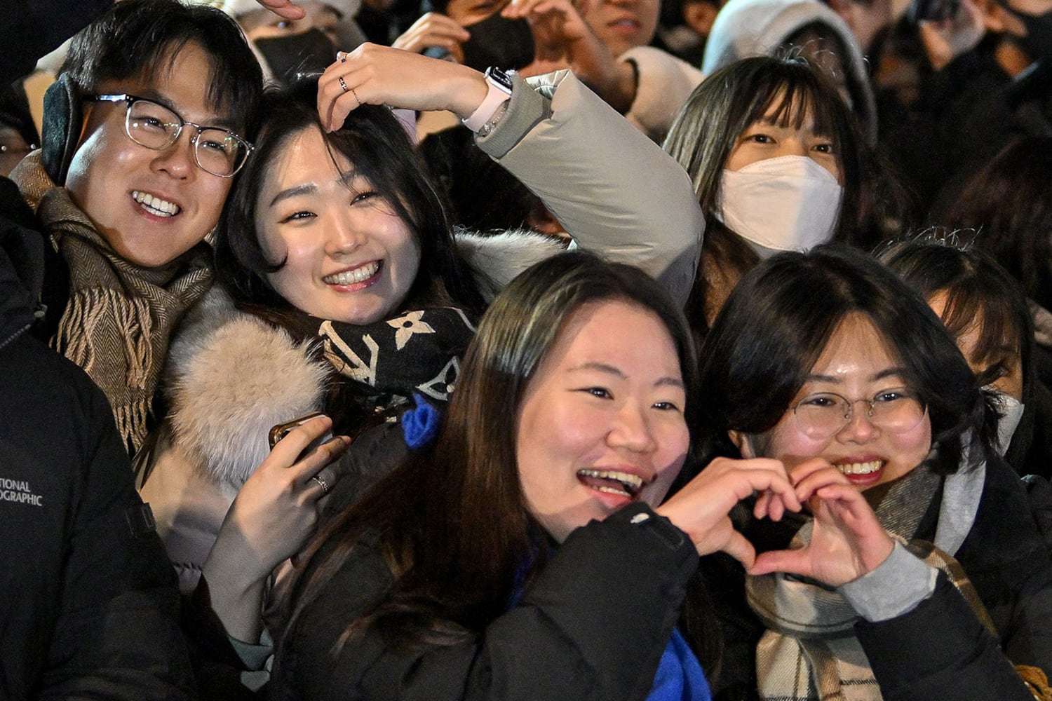 People gesture to make hearts at the Bosingak pavilion in central Seoul on Jan. 1, 2025.