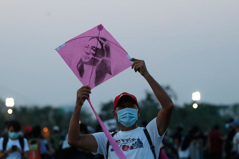 2021 年 3 月 20 日，泰国学生领导的民主运动在曼谷举行集会，一名男子准备释放一张带有被拘留学运人士图像的风筝，该风筝将在大皇宫附近的 Sanam Luang 场地举行的抗议活动中飞行。 （美联社）