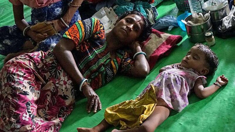 A woman sleeps next to a baby on the floor of a makeshift camp for displaced Hindus at a disused soccer stadium in Sittwe, western Myanmar's Rakhine state, Sept. 22, 2017.