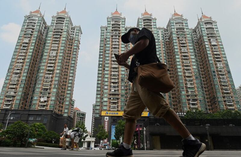 一名男子走过中国广东省广州市恒大的住宅区。（AFP）