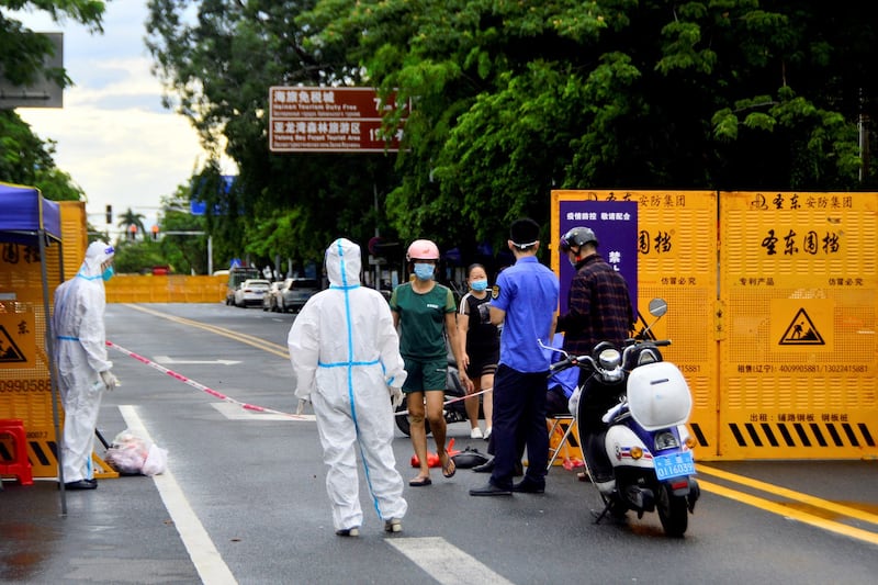 A delivery courier places food near a barricade at an entrance to a residential compound, amid lockdown measures to curb theCOVID-19 outbreak in Sanya, Hainan province, China August 8, 2022. Credit: China Daily via Reuters