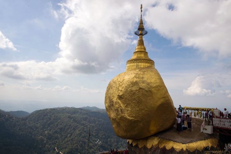 Devotees pray before a huge rock covered with layers of gold at the Kyaiktiyo Pagoda on Mt. Kyaiktiyo, a popular Buddhist pilgrimage site and tourist attraction in southeastern Myanmar's Mon state, in a file photo. Credit: AFP