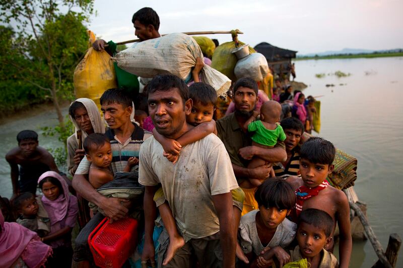 Fleeing persecution in Myanmar, Rohingya Muslims carry their young children and belongings after crossing the border from Myanmar into Bangladesh, Nov. 1, 2017. Credit: AP