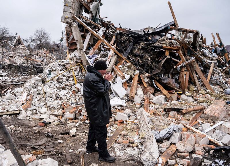 A local resident smokes at the remains of a residential building destroyed by shelling, as Russia's invasion of Ukraine continues, in Zhytomyr, Ukraine March 2, 2022. Credit: Reuters