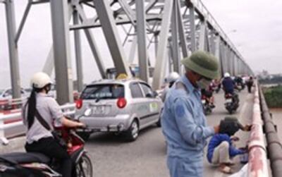 Một công nhân đang sơn sửa cầu Thăng Long, Hà Nội. AFP photo