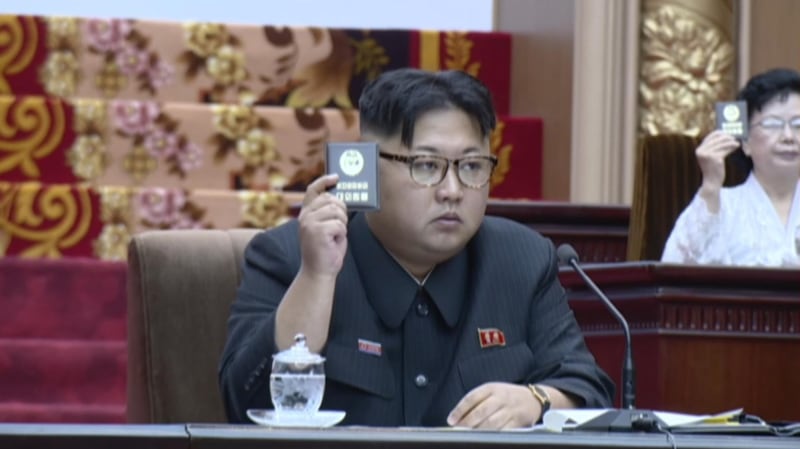 North Korean leader Kim Jong Un raises his Party Membership Card to vote during North Korea's Supreme People's Assembly in Pyongyang, North Korea, June 29, 2016.