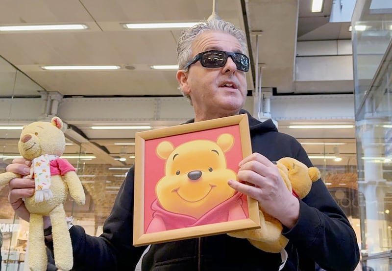 YouTuber Brendan Kavanagh holds up a Winnie the Pooh doll, which is banned in China, after playing the public piano at London's St. Pancras railway station on Jan. 26, 2024. (RFA)