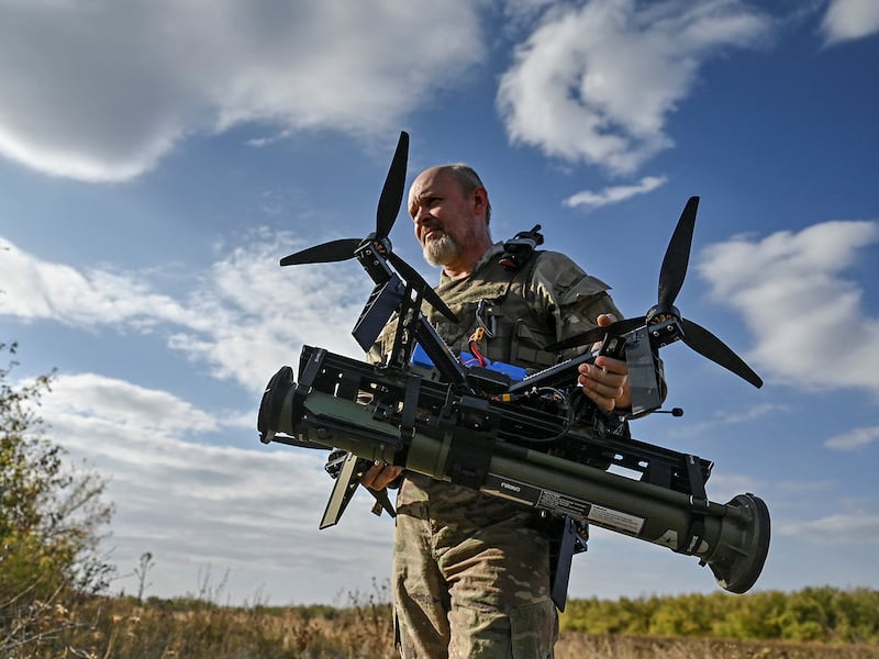 A Ukrainian soldier, of the 'Bulava' Unmanned Aerial Vehicles Unit, carries an FPV drone with an attached portable grenade launcher at a position near a frontline, amid Russia's attack on Ukraine, in Zaporizhzhia region, Ukraine, Oct. 11, 2024.