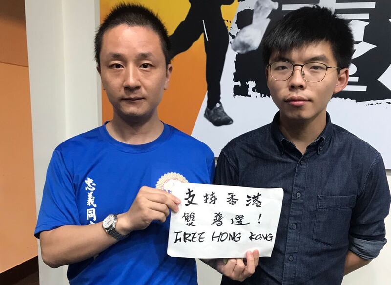 滞台中国大陆异议青年温起锋（左）声援香港反送中，在会后要求和黄之锋（右）合影。（温起锋提供）