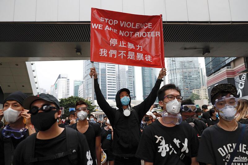 2019年6月17日，香港示威者在立法会附近手持标语“停止暴力 我们不是暴徒”。（美联社） 