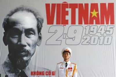 Một lính đứng gác trước biểu ngữ có ảnh Ô. Hồ Chí Minh. AFP