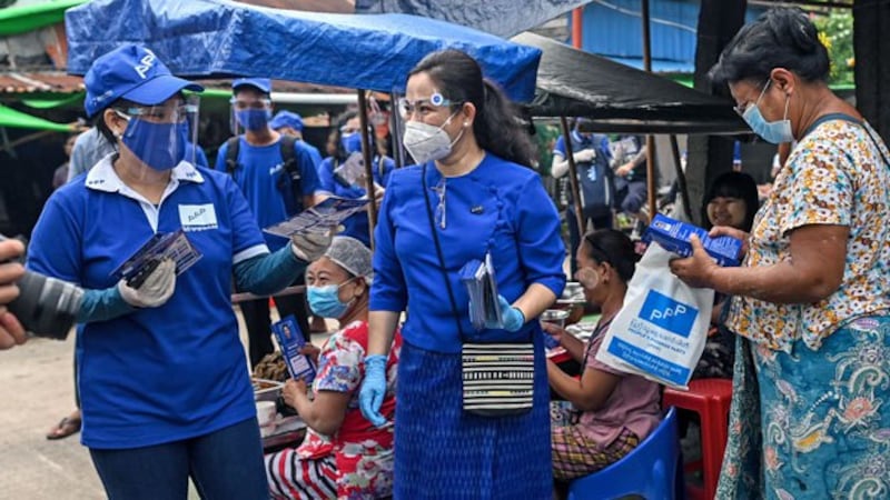 Thet Thet Khine (C), chairwoman of the People's Pioneer Party, hands out campaign literature to vendors during the launch of the party's campaign ahead of Myanmar's general elections, in Yangon, Sept. 8, 2020.