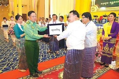 Senior General Min Aung Hlaing presents a plaque to the Mandalay Myoma Culture Troupe during the opening ceremony of Yadanarbon Hall in Mandalay, May 17, 2021. RFA