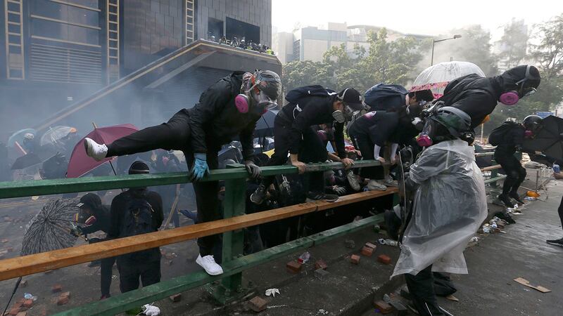 2019年11月18日，示威者在香港香港理工大学与警察发生冲突时爬上了栏杆。（美联社） 