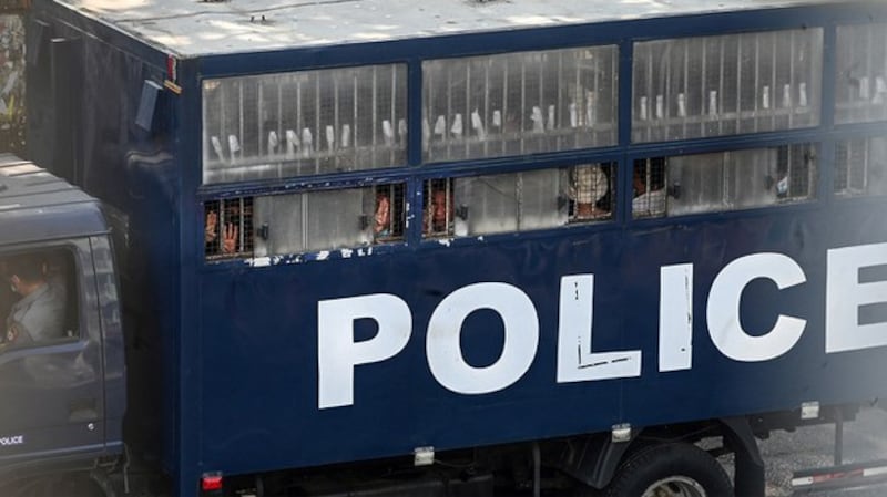 Protesters make the three-finger salute from a police truck in Yangon, after a crackdown on demonstrations against the military coup, Feb. 27, 2021. AFP