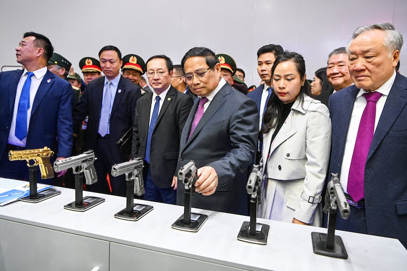 Vietnam's Prime Minister Pham Minh Chinh (C) checks Turkish-made guns during the Vietnam 2024 International Defense Expo in Hanoi on December 19, 2024. An international arms fair began in Vietnam, as the Southeast Asian country looks to diversify its weapons supply from long-standing defense partner Russia.