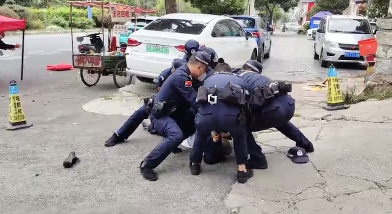 贵阳街头一男子拒绝戴口罩，被几个公安按倒在地。（视频截图/古亭提供）