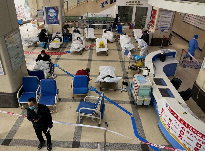 A man stands in front of a cordoned-off area, where COVID-19 patients lie on hospital beds, in the lobby of the Chongqing No. 5 People's Hospital in China's southwestern city of Chongqing on Friday, Dec. 23, 2022. Credit: AFP