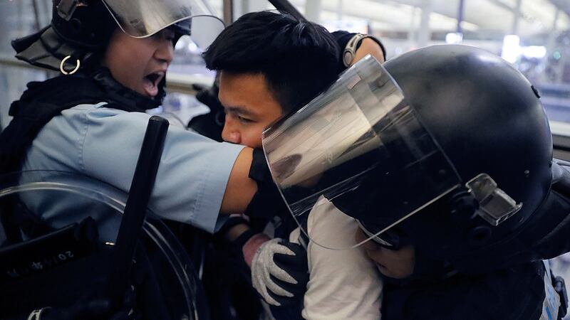 2019年8月13日，在香港机场示威活动中，防暴警察与示威者。（美联社）