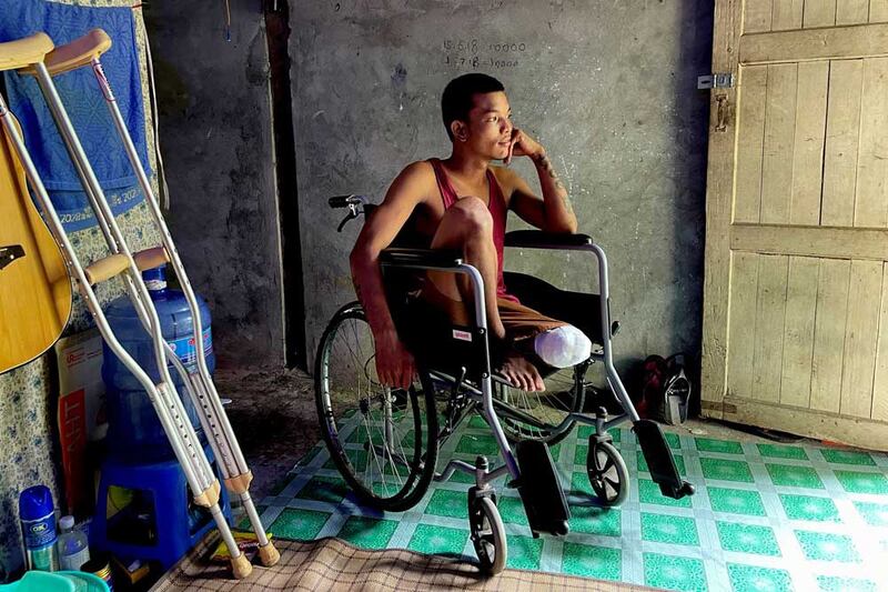 Ko Phyo, 24, sits in his wheelchair at his home on the outskirts of Yangon, Myanmar. He says the soldier who shot him removed the bullet with a knife and a policeman he knew took him to a military hospital. "I started feeling the pain, and I couldn't bear it. I told them to cut off my leg immediately. They cut it on the seventh day." (REUTERS)