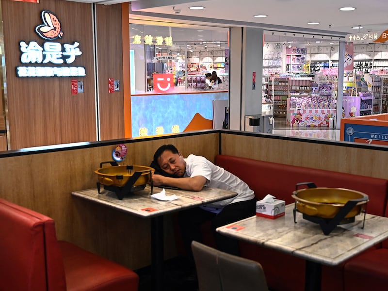 A man rests at a restaurant inside a shopping mall in Beijing, China, August 14, 2024.