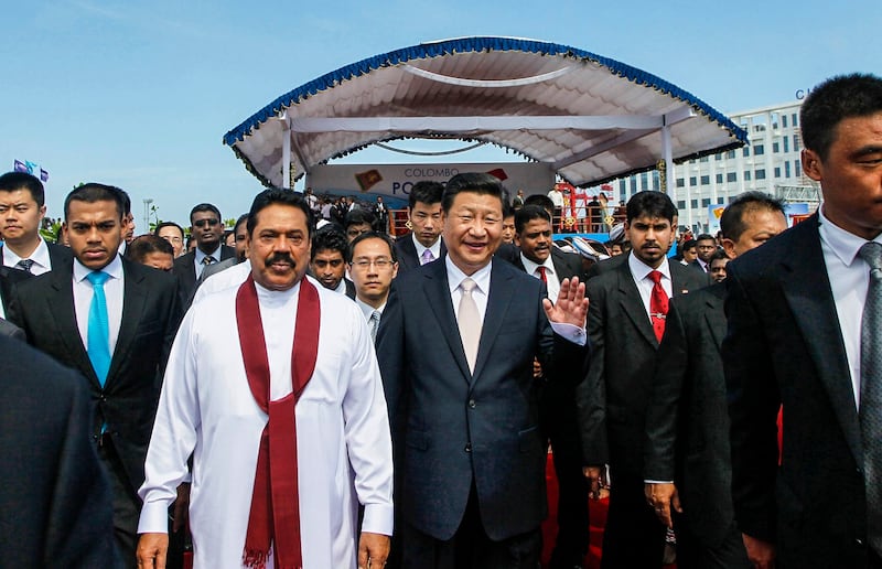 Sri Lankan President Mahinda Rajapaksa, in white, walks with Chinese President Xi Jinping after officially launching a project to build a $1.4 billion port city on an artificial island off Colombo, Sri Lanka, Sept. 17, 2014. Credit: AP