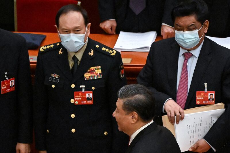 China's President Xi Jinping walks past China's Defence Minister Wei Fenghe, left, after the opening session of the National People's Congress in Beijing on March 5, 2023. (Noel Celis/AFP)