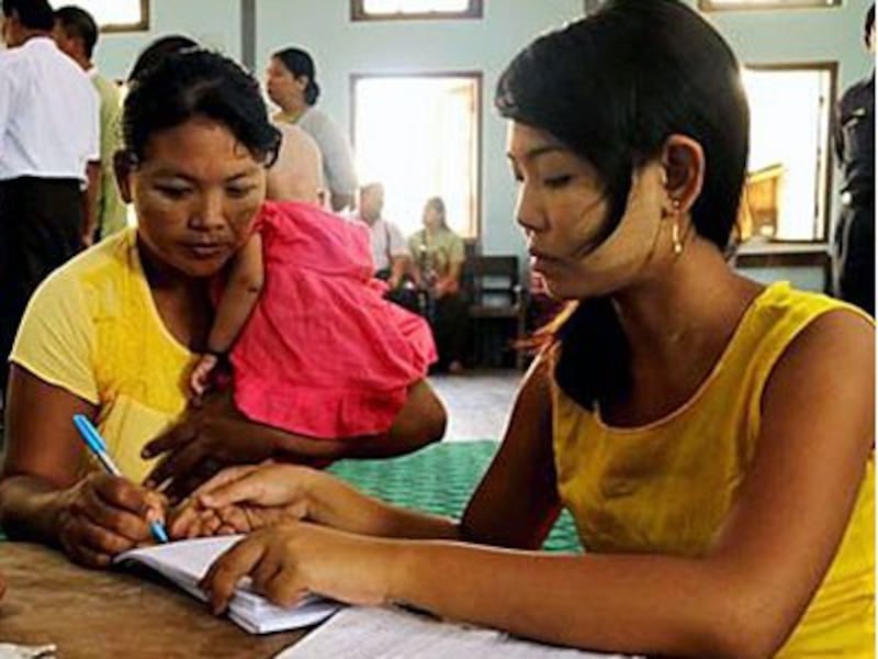 A Myanmar woman is given a document declaring her an illegal squatter of a ward in Yangon's Bahan township, June 12, 2017.