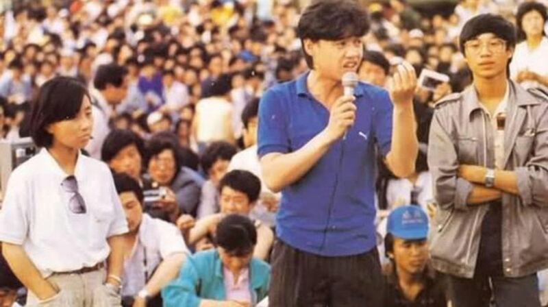 1989年5月27日，吾尔开希（中）在天安门广场学生大会上讲话。旁边是柴玲（左）和王丹（右）。（六四档案图）