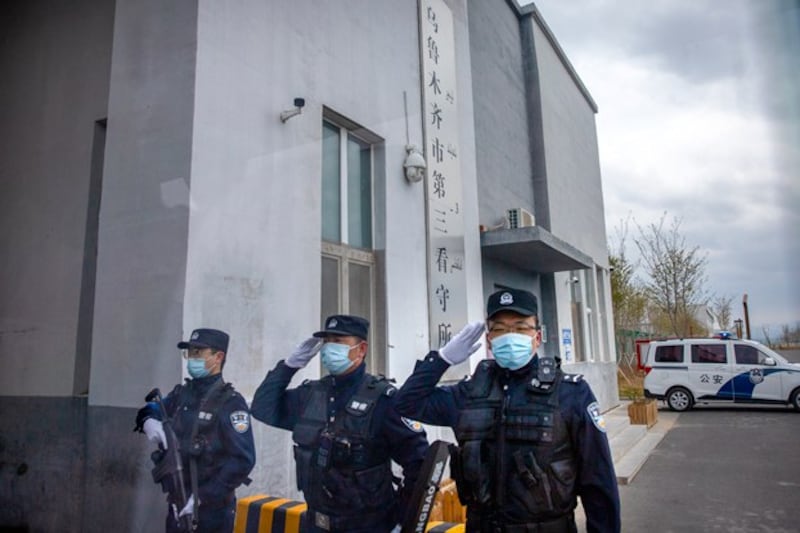 Police officers salute at the outer entrance of the Urumqi No. 3 Detention Center in Dabancheng in northwestern China's Xinjiang Uyghur Autonomous Region, April 23, 2021.