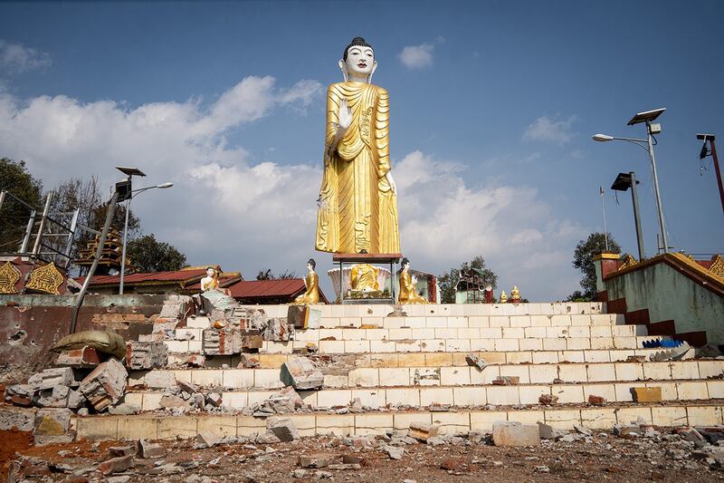 Debris lies scattered around a damaged statue of Buddha following fighting between Myanmar's military and the Kachin Independence Army in Nam Hpat Kar, Kutkai township in Myanmar's northern Shan State, Feb. 4, 2024. (AFP)