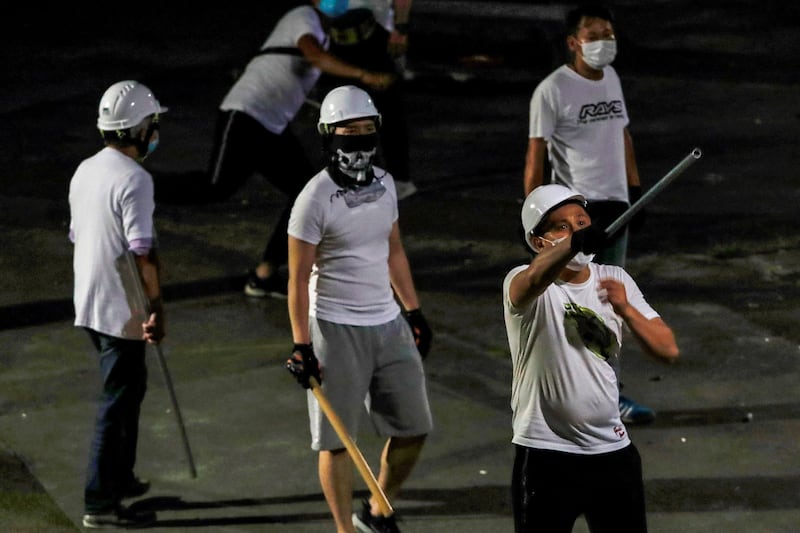 Men in white T-shirts with poles are seen in Yuen Long after attacking anti-extradition bill demonstrators at a train station, in Hong Kong, China July 22, 2019. Credit: Reuters