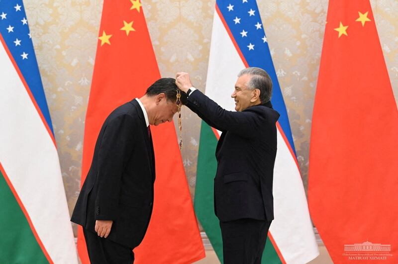 President Xi Jinping receives the Order "Oliy Darazhali Dustlik" from Uzbekistan's President Shavkat Mirziyoyev during their meeting on the sidelines of the Shanghai Cooperation Organization (SCO) summit in Samarkand, Uzbekistan, Sept. 15, 2022. Credit: Press service of the President of Uzbekistan/Handout via Reuters