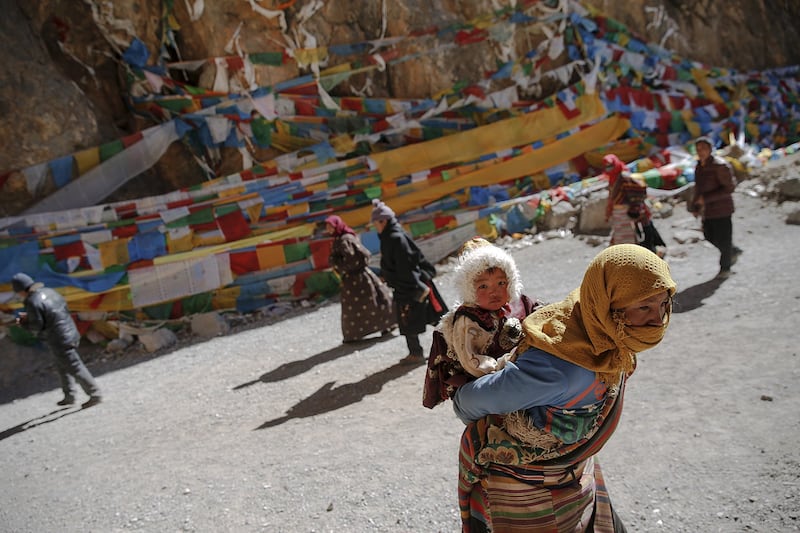 A Tibetan woman carries a child as they visit Namtso lake in the Tibet Autonomous Region of China, Nov. 18, 2015. (Damir Sagolj/Reuters)