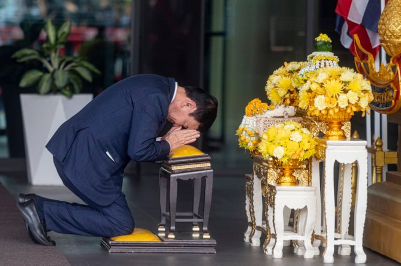 Thaksin Shinawatra kneels before a portrait of the king and queen at the Mjets private terminal at Don Mueang International Airport, Aug. 22, 2023. Credit: Thai News Pix/BenarNews