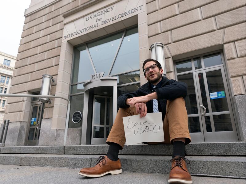 A United States Agency for International Development, USAID, contract worker sits in front of the USAID office in Washington, Feb. 3, 2025.