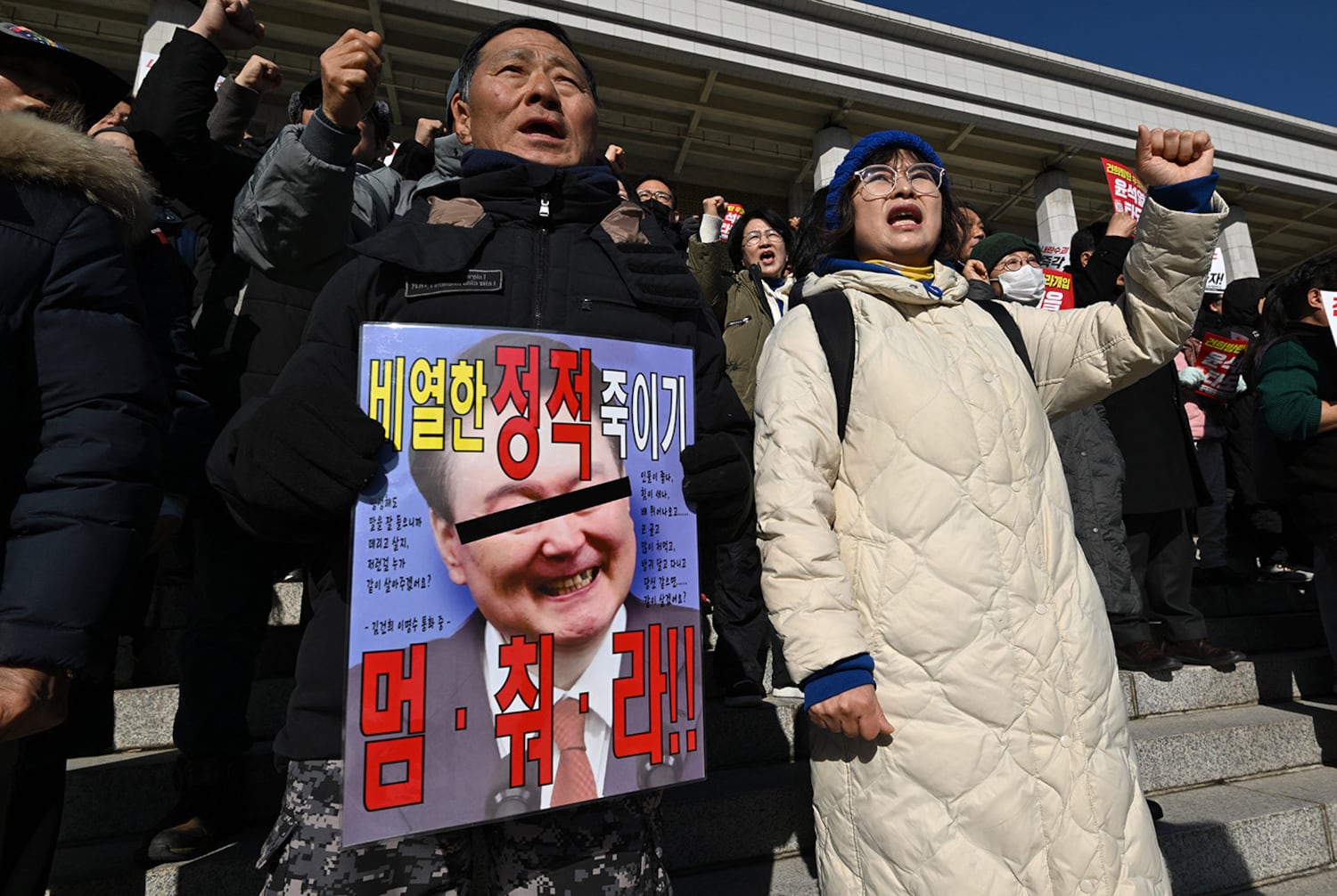 Members of South Korea's main opposition Democratic Party hold a placard showing South Korean President Yoon Suk Yeol during a rally against him at the National Assembly in Seoul on Dec. 4, 2024.